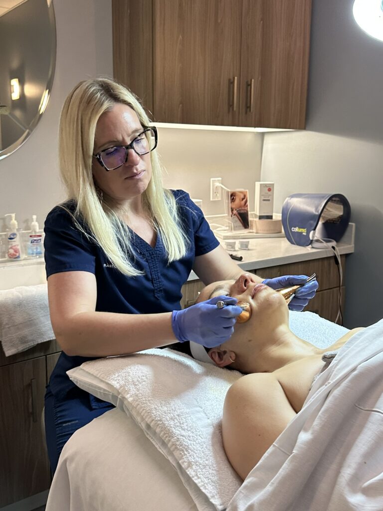 Kelly, aesthician, performing an Osmosis facial treatment on a patient.